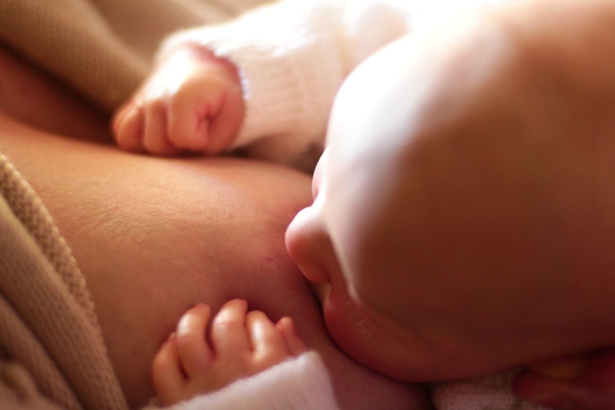 Newborn feeding close to mom, protecting milk supply with overnight care