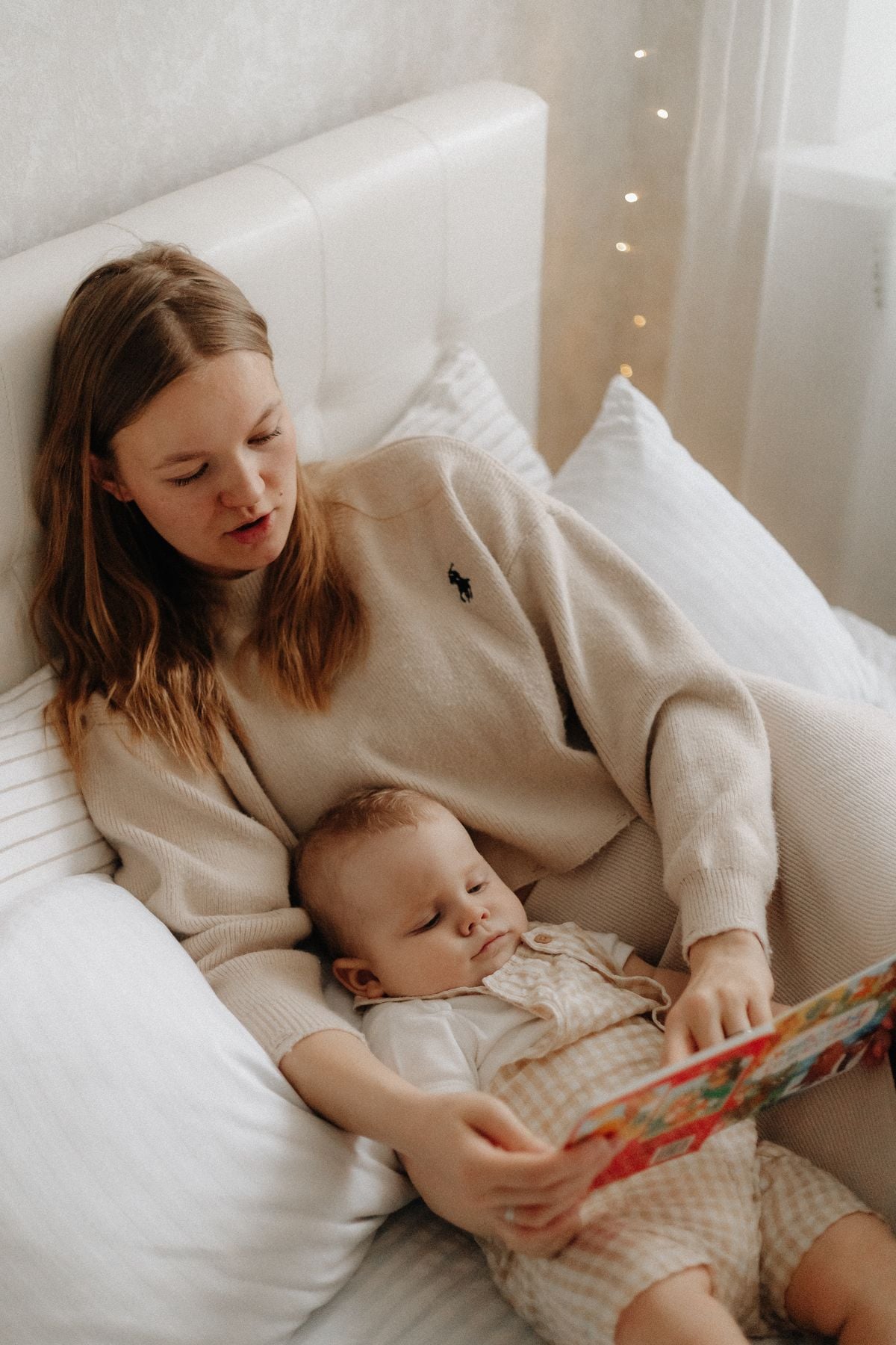 Mother reading a picture book to her newborn