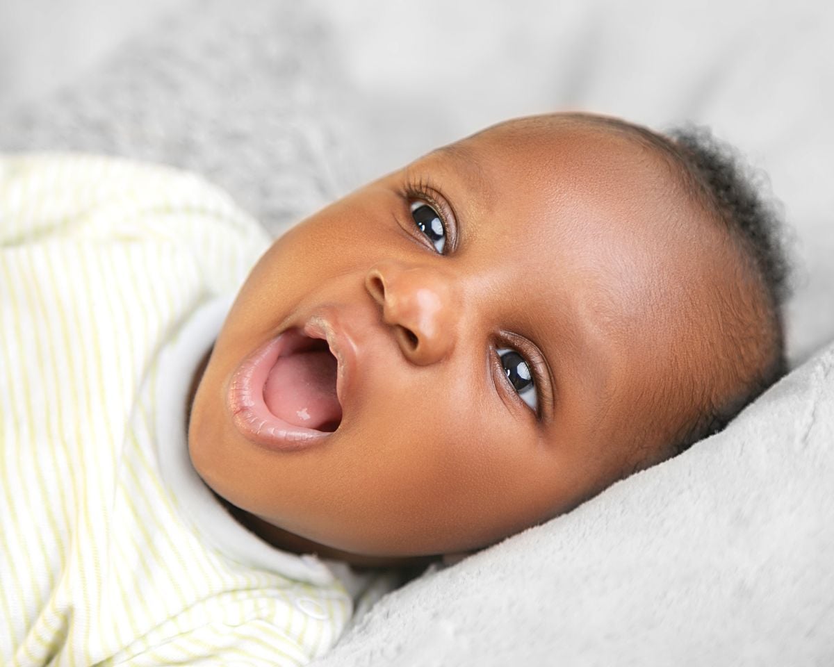Newborn awake time: a bright-eyed baby looking up from a soft blanket